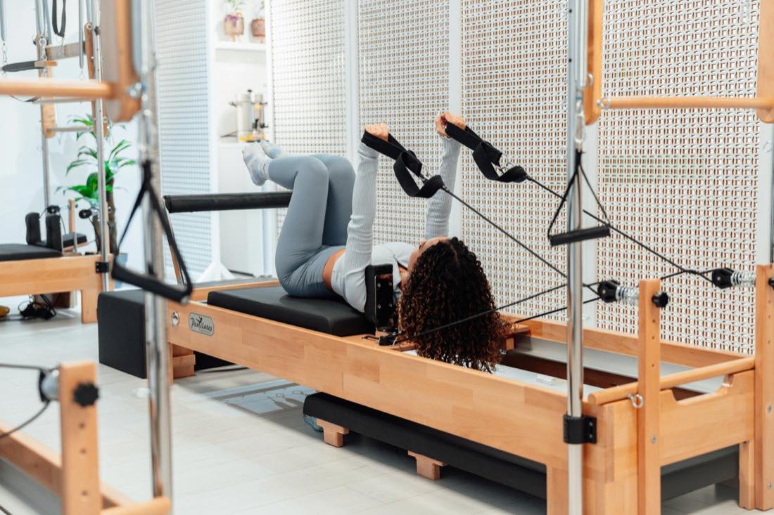 Séance individuelle sur un appareil de Pilates, dans une pièce lumineuse